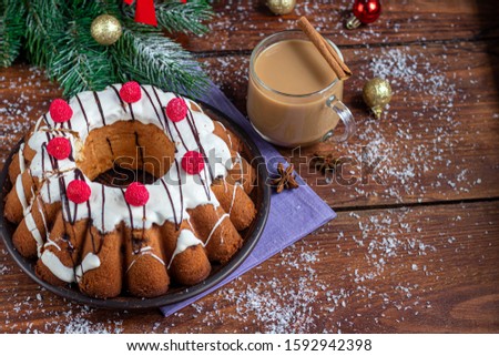 Beautiful festive cupcake decorated with whipped squirrels and raspberry jelly. On a brown, wooden background. New Year's and Christmas. Copy space.