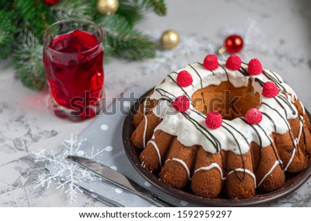 Beautiful festive cupcake decorated with whipped squirrels and raspberry jelly. On a light gray background under concrete. New Year's and Christmas. Copy space.