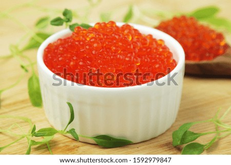 A small ceramic bowl with red caviar	