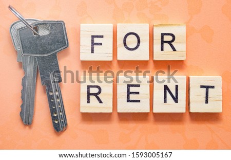 For rent - inscription from wooden blocks with letters near keys, concept. 