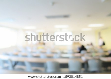 Blurred of lecture room or meeting room with long table, chairs, projector, and big window. Education, business and technology concept. Royalty-Free Stock Photo #1593014851
