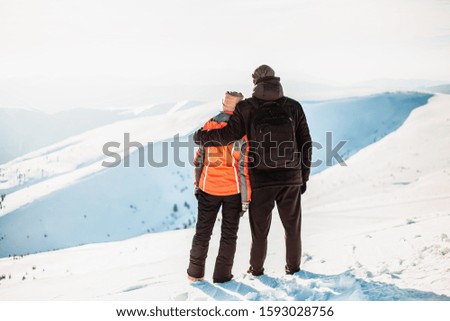 Happy couple in a snowy mountains, young family, sports wear, winter holidays, together, love, hats, stylish, nature, cold, travel, attractive, casual, laugh, bearded man, pretty, handsome