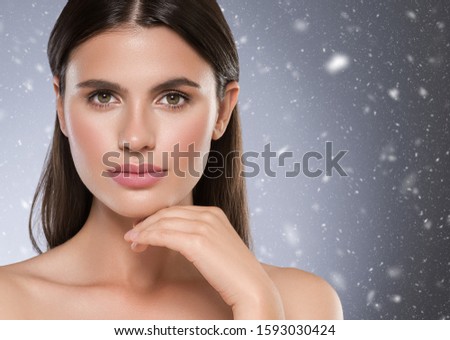 Winter beauty woman face beautiful skin healthy skin and hair natural casual makeup snowflakes background 
