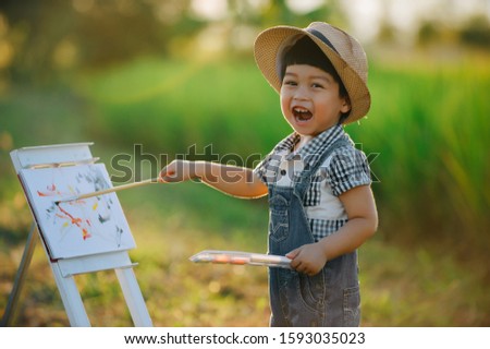 Little child Painting with water colors outdoor in nature park.a little painter.