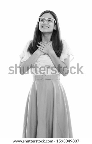 Thoughtful happy young woman smiling with hands on chest