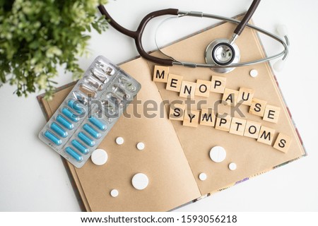 Concept. The inscription from the letters menopause. Symptoms of Menopause Harmonious changes in women older than 40 years. Royalty-Free Stock Photo #1593056218