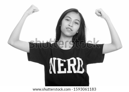 Studio shot of young Asian teenage nerd girl flexing both arms