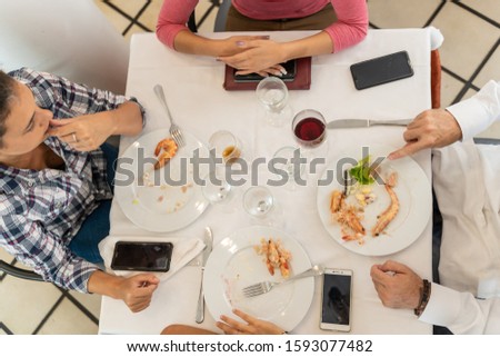 Stock photo of a table with four people who have already finished eating in a restaurant