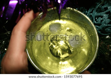 glass with drink with ice on Christmas tree background