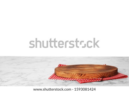 Folded kitchen towel and cutting board on wooden table. Space for design