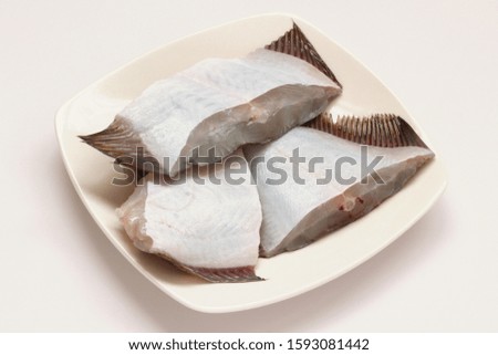 Pieces of Raw Flounder on White Plate