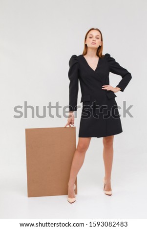 business woman holding a blank billboard. elegance lady in black dress isolated on white background
