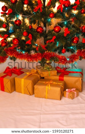Boxes with gifts on a light, blue background and under the Christmas tree. Gift in the hand. Christmas presents, Nicholas Day, Valentine's Day. Bright boxes with bright ribbons. Gifts in Macro