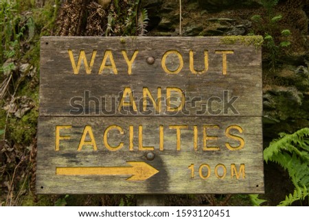 "Way Out and Facilities" Sign One Hundred Metres to the Right in Woodland at Lydford Gorge on the Edge of Dartmoor National Park in Rural Devon, England, UK