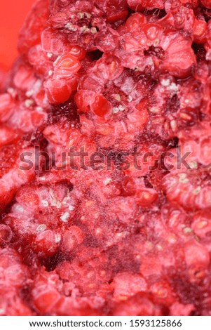 Food background. Freshly frozen raspberries, turned into a juicy piece of ice during freezing.