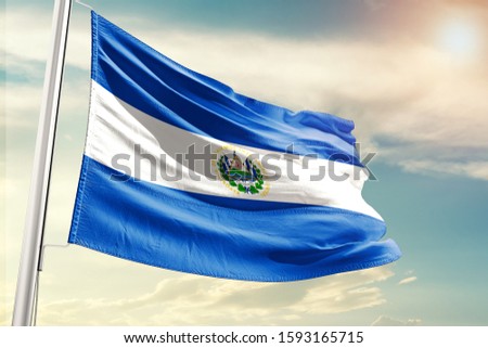 El Salvador national flag cloth fabric waving on the sky with beautiful sun light