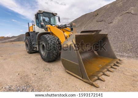 Mountain of gravel and excavator for transport