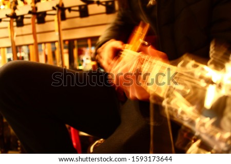 Blurred portrait of man playing guitar from side