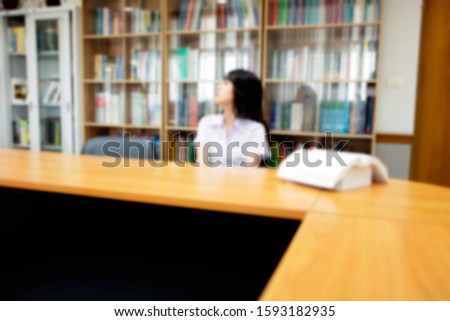 Blurred picture of a girl in a library as an education concept background for article related to school, college, vocational institute, or university campus. Blurry image of student sitting in class 