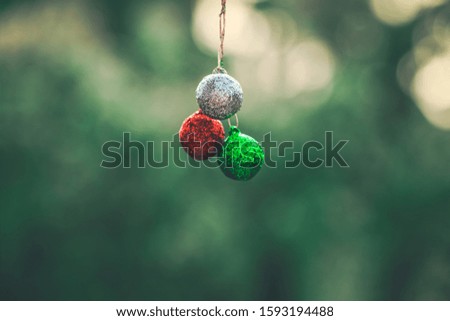 Christmas Background - red, green, silver balls hanging outside on the porch with copy space. Concept photo of winter holiday, greeting card, postcard, Christian tradition, culture.