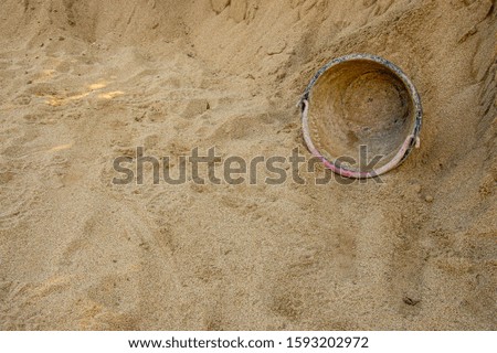 Old plastic bucket left on sand in construction site