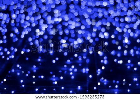 Abstract bokeh background with out of focus lights of classic blue pantone color 