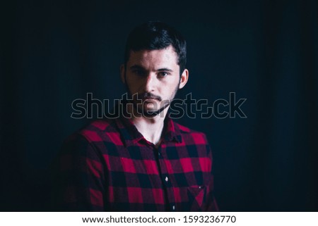 Young Handsome Man in Plaid Shirt on Dark Background