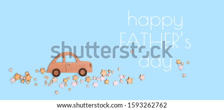 Happy Father's day greetings card. wooden toy car and stars road on blue background. flat lay.