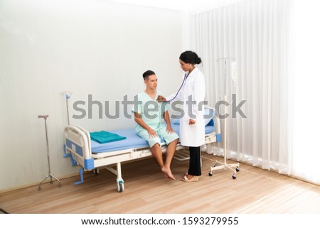 Portrait of African doctor woman working in medical clinic and listening to heartbeat and breathing of male patient using stethoscope. 