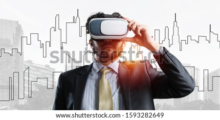 Double exposure of businessman in virtual helmet against cityscape background