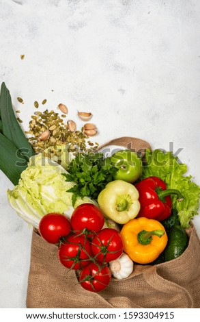 Eco-friendly fabric bag full of fresh vegetables on a light background. top view. Zero waste purchases concept. Healthy balanced food.
