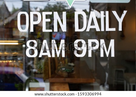 A cafe open sign showing daily time operating hours