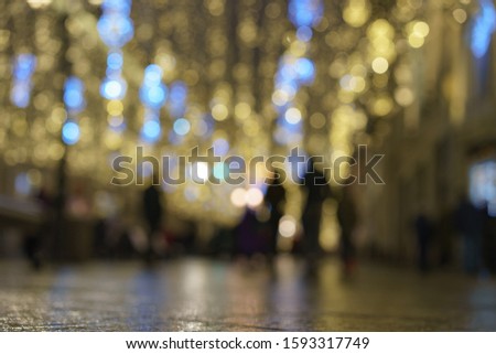 Defocused photography of New Year lights on the city street Nikolskaya in Moscow in night. Christmas mood, festive atmosphere. Suitable as template and background for postcards, greeting cards.