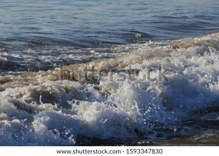 waves hitting sandy beach in Wales