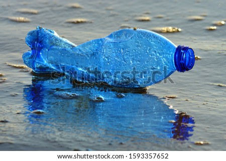 Plastic bottle pollution on a sandy beach.