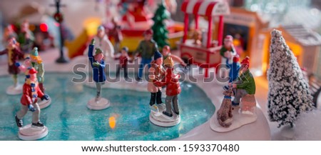 Christmas village. Houses, railway and train, outdoor activities, sleighs, ice skates in a snowy Christmas landscape at night. Christmas tree and snowman. concept for greeting card or postcard Banner