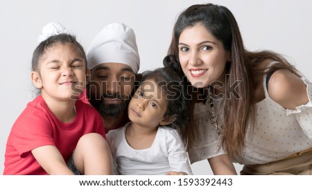 Loving family portrait studio photo shoot. Father, mother, son and daughter together as a beautiful family. Adorable family picture.