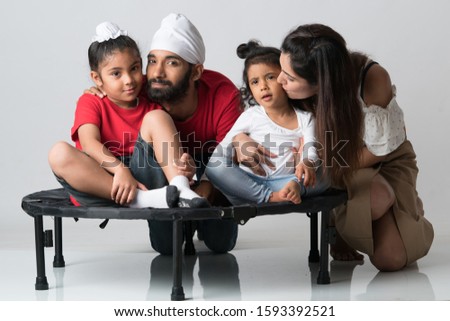 Loving family portrait studio photo shoot. Father, mother, son and daughter together as a beautiful family. Adorable family picture.