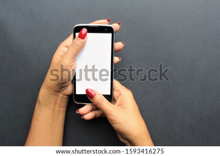 women hands holding smartphone put  thumbs up and down on the phone.photo isolate black background copy space 