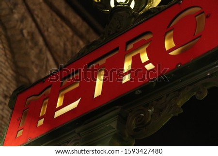 low-angle close-up of a vintage metro/ subway sign in the dark in Paris, France