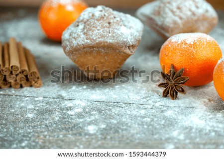 delicious fresh muffins with flour on a wooden table