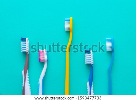 Set of different toothbrushes on turquoise background. Health care concept.