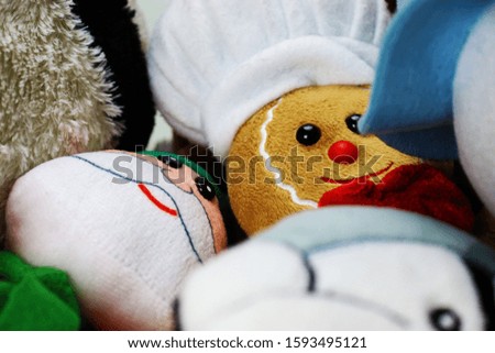 Stuffed gingerbread man in focus with other christmas toys.