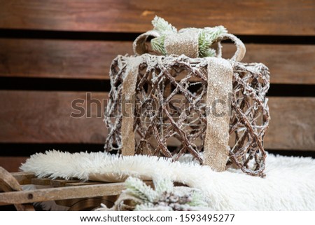 brown christmas gift with snow on wooden background