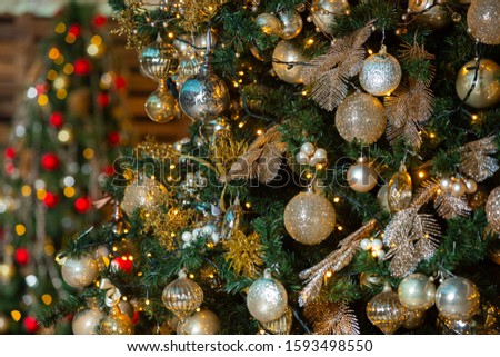 Red and gold Christmas ball on Christmas tree with light bulb on wooden wall background