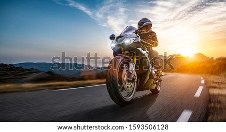 motorcycle on the coast road riding. having fun driving the empty highway on a motorbike tour journey. copyspace for your individual text. Royalty-Free Stock Photo #1593506128