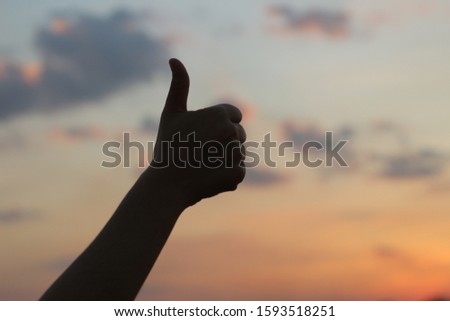 Silhouette of hand with sky sunset background.