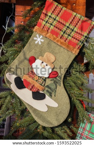 Christmas stocking with gifts hanging on dark old wooden background