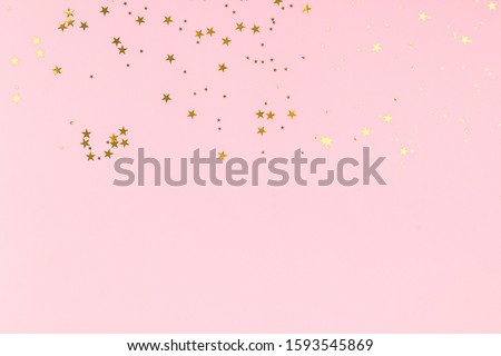 Golden stars glitter confetti in abstract style on pink background. Gold sparkles texture. Holiday new year backdrop. Anniversary, birthday. Greeting card template. Royalty-Free Stock Photo #1593545869