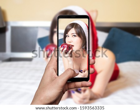 women hand  taking a picture with your mobile phone a women in santa claus cosplay